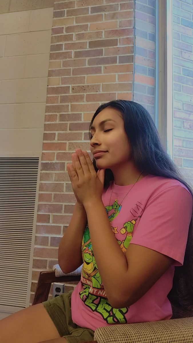 In Logansport Savings Bank Student Union, sophomore Yareli Hernandez prays.