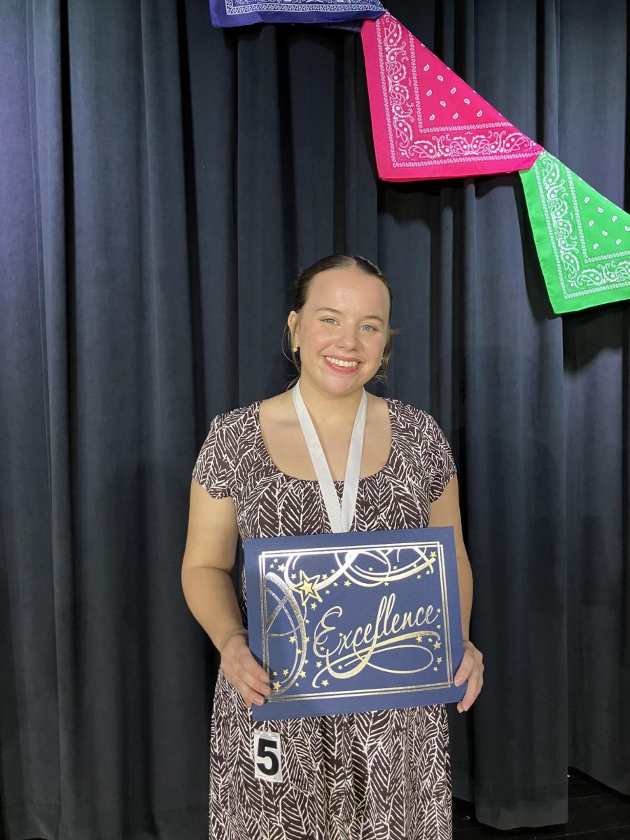 Posing for a photograph after the program, senior Elizabeth Foster shows off her award. (Photo courtesy of Michaela Slisher)