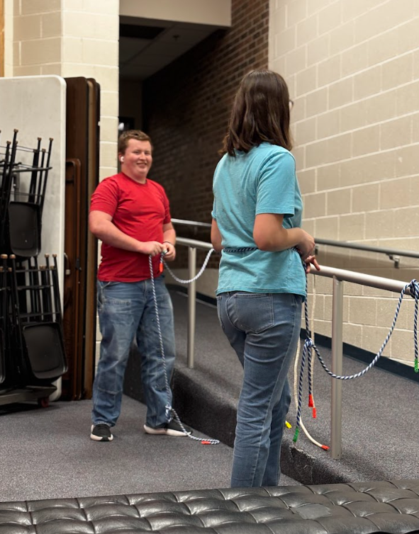 From left to right, seniors Evan Adams and Cunningham talk while untying the knots they practiced making.