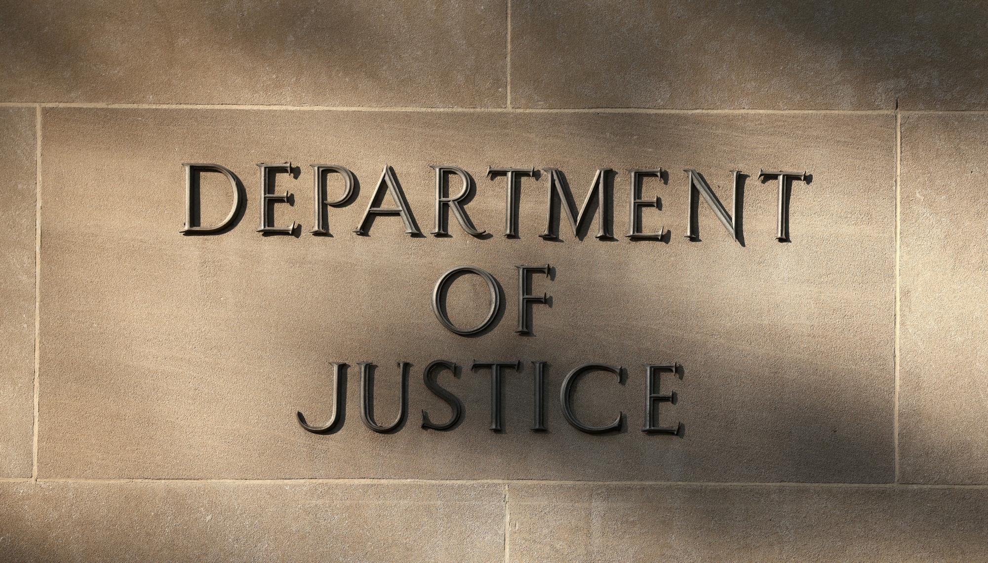 Shadows are cast on a sign at the Department of Justice building in Washington, D.C., U.S., September 23, 2025. REUTERS/Kevin Lamarque