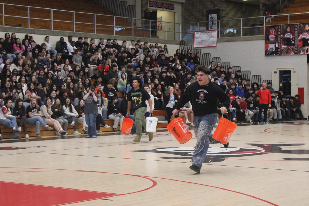 With one bucket each hand, junior Noah Picardo races against competitors from two teams.