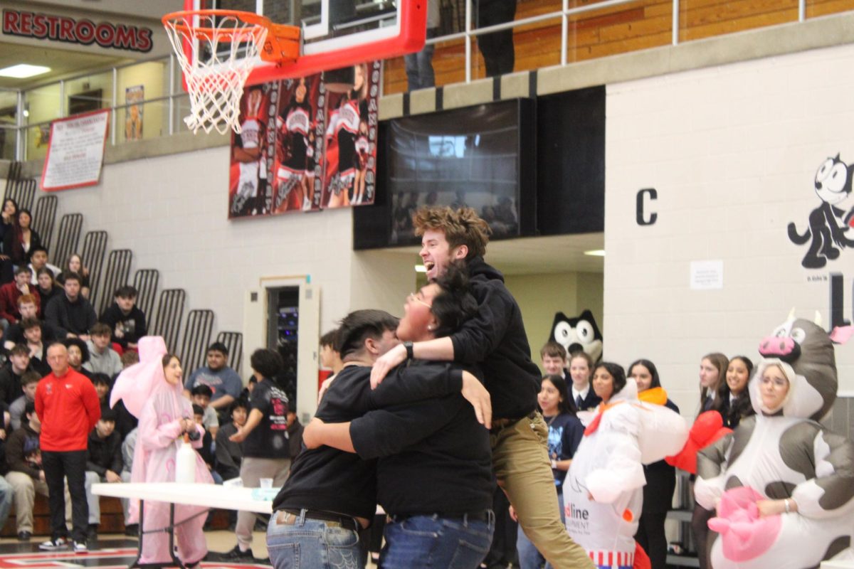 Winning the games, the junior team celebrates as they hug and jump in excitement. 