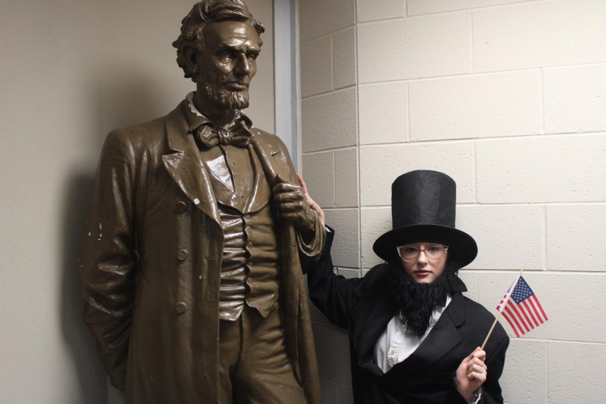 Tuesday is Patriotic Day during the FFA Spirit Week. In this photo, the student is dressed up as the president behind her to represent this day. This statue of Abraham Lincoln was found, and a photo was taken in the second room of the Berry Bean at Logansport High School. This spot was heavily suggested by the student herself. She believed it was perfect as a spot for a sense of humor. 