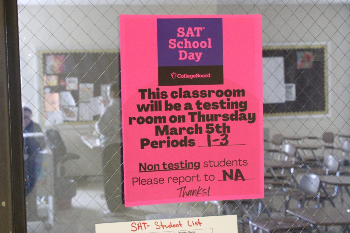 Posters listing testing room assignments are displayed on the doors of classrooms in the upstairs G-wing hallway.
