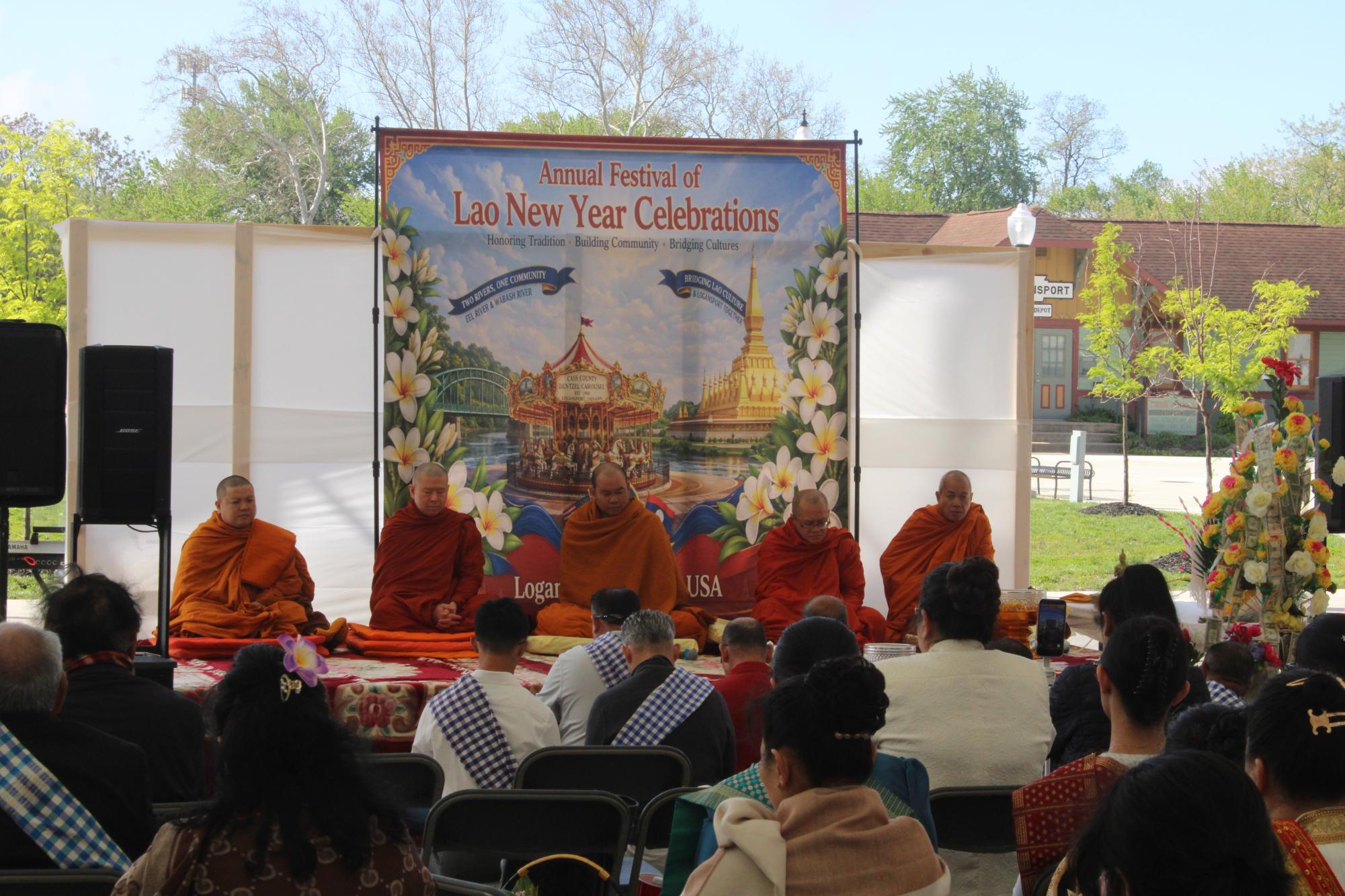 Monks praying on a stage as Buddhist members of the Logansport community pray with them. The Monks all came from different places in Indiana and marked the start of the celebration.